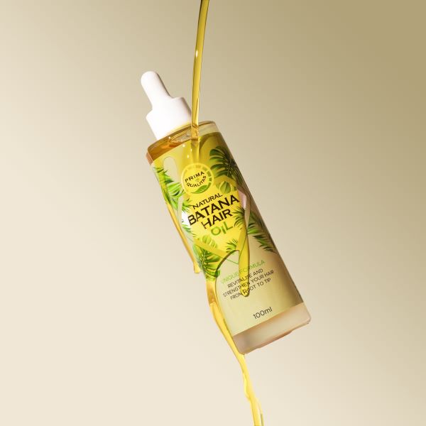 Bottle of Banana Hair Oil with dropper on a beige background